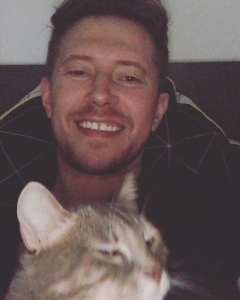 Robert smiling with a cat