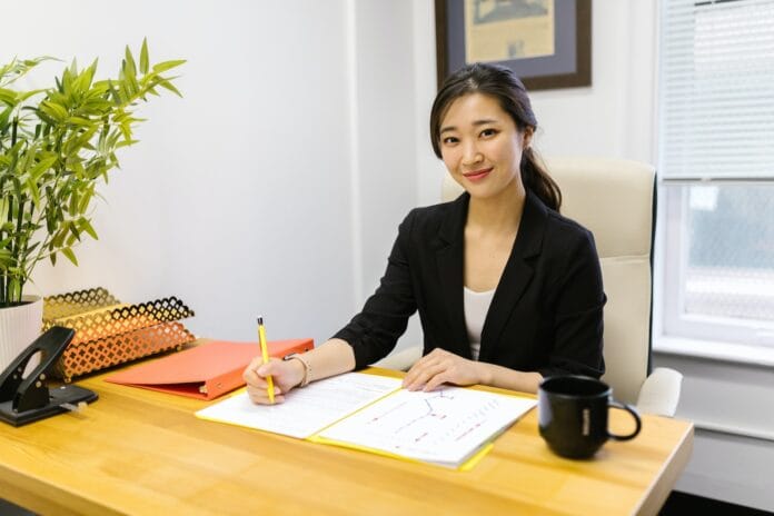 Woman in Black Blazer Sitting at the Table