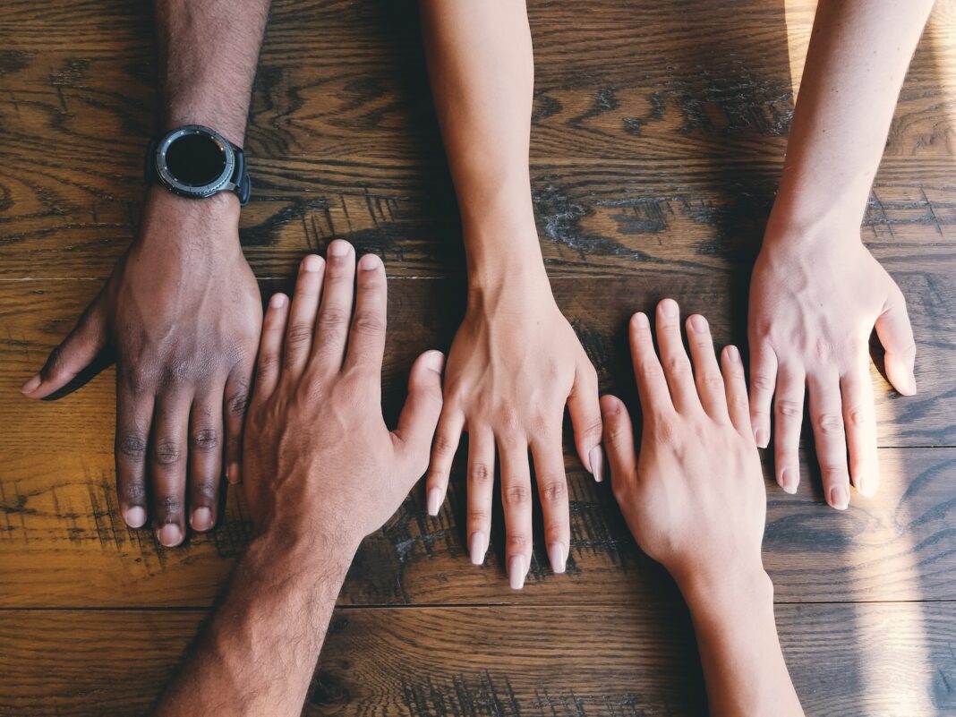 Photo by Clay Banks five human hands on brown surface