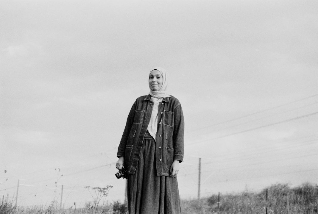 A woman in a hijab standing in a field