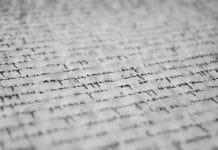 Close-up of vintage handwritten text on old paper, showcasing detailed penmanship and texture.
