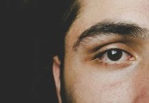 Detailed close-up of a man's eye highlighting natural eyebrow and skin texture.