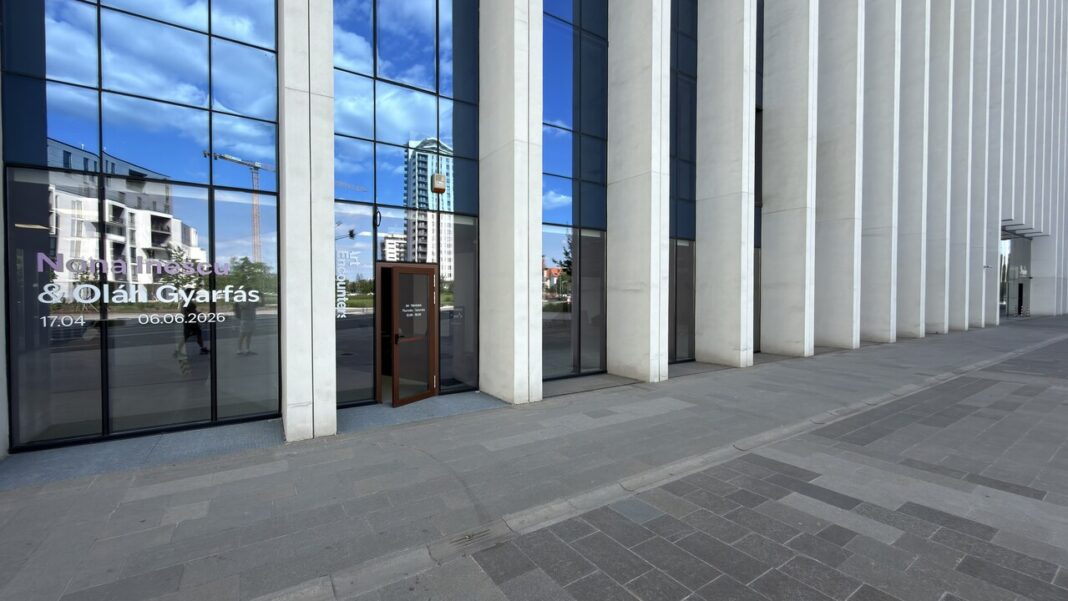 How accommodation, tour, and travel businesses get found in 2026 Hotel concierge desk with an open travel directory of guesthouses ribbon-marked at one listing, beside a brass bell and key board