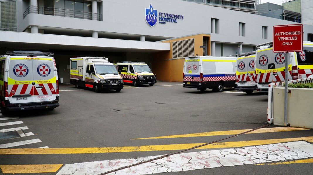 Hospital emergency entrance illustrating healthcare infrastructure for physician directory article Ambulances parked at a hospital emergency entrance with checkerboard livery, representing healthcare infrastructure and medical service accessibility in Australia.