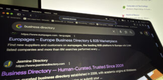 How to choose a business directory worth being in Computer monitor displays Google search results for business directories including Europages and Jasmine Directory, illustrating the research process for selecting quality business listing platforms.