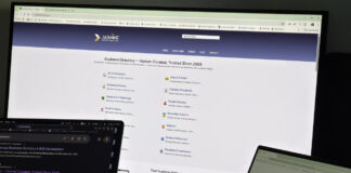 Two laptops side by side display a business directory website with search and category pages, illustrating the digital interface for listing law firms in online directories.