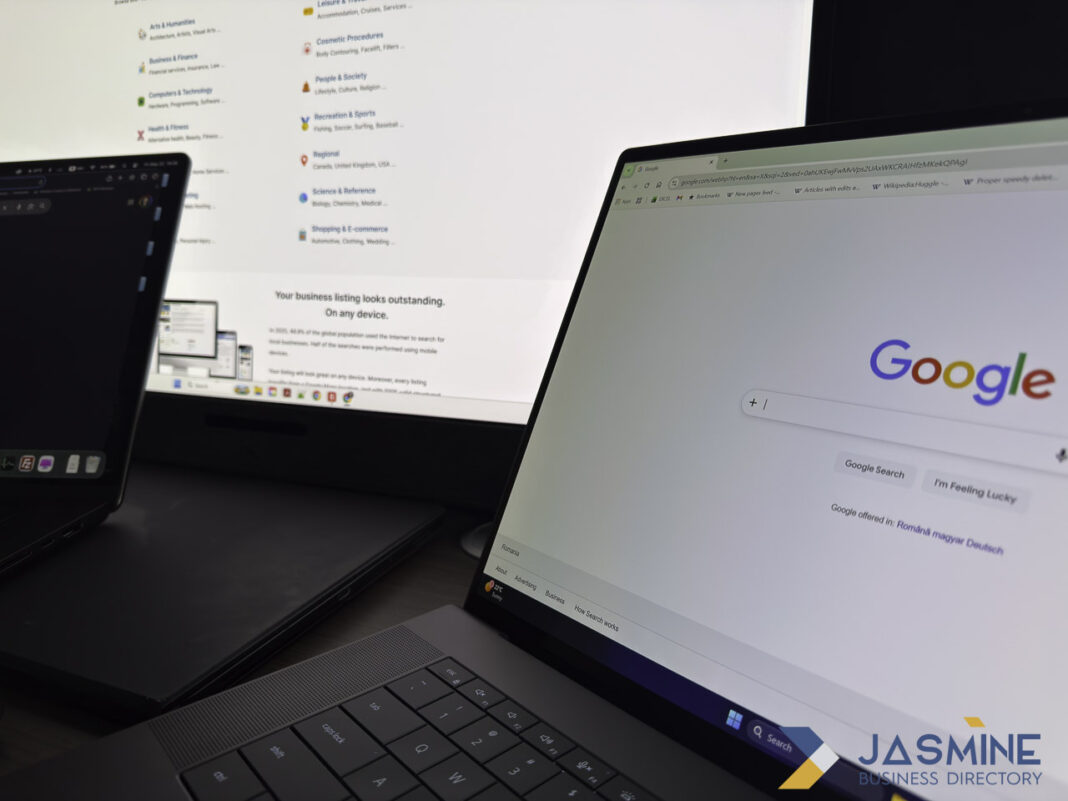 Dual laptop workspace showing business listing and search platforms for service comparison research Two laptops side by side display Google services and a business listing directory interface, illustrating the research process for comparing business listing platforms.