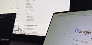Choosing a business listing service: what to look for Two laptops side by side display Google services and a business listing directory interface, illustrating the research process for comparing business listing platforms.