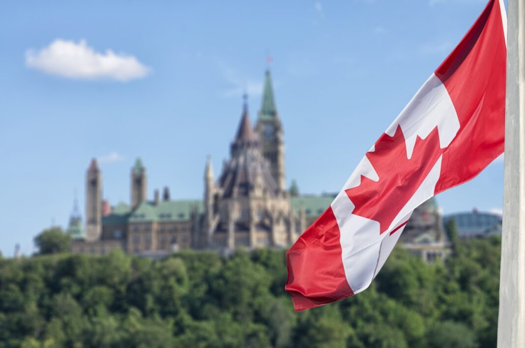 Canadian flag and Parliament Hill symbolizing the national legal framework for law firm directories Canadian flag waves in front of Parliament Hill's Peace Tower in Ottawa, representing the national legal framework underpinning Canadian law firm directories.