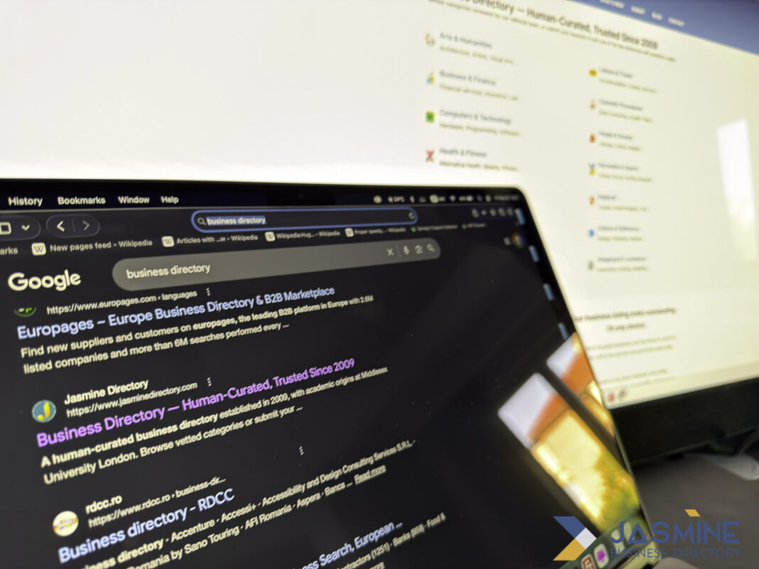 Multi-screen workspace showing business directory search results demonstrates systematic listing audit process Two computer screens display Google search results for business directories in dark mode, illustrating the digital tools used for auditing business listings.