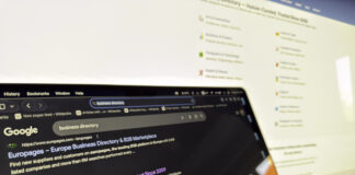 How to audit your business listings in 2026 Two computer screens display Google search results for business directories in dark mode, illustrating the digital tools used for auditing business listings.