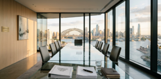 Modern conference room with glass table and harbor view through floor-to-ceiling windows, representing the professional environment of growing Australian law firms expanding their market presence.