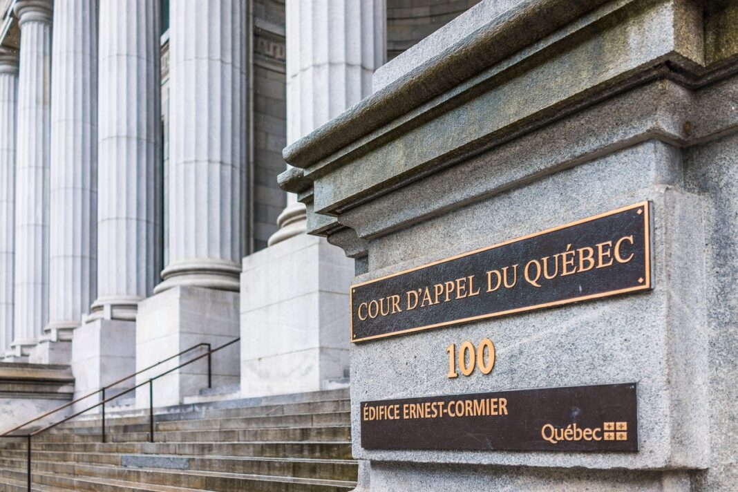 Historic Quebec courthouse entrance exemplifies institutional presence valued in Canadian law firm directory searches Entrance to Quebec Court of Appeal building with bronze plaques on granite pillar and neoclassical columns, representing institutional credibility clients seek when selecting law firms.