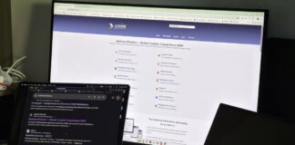 A MacBook and external monitor display a business directory website, representing digital tools that help Australian sole practitioners enhance their online professional visibility.