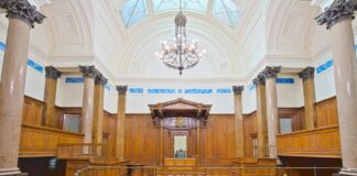 Finding counsel in the Connecticut law firm directory Formal courtroom interior with curved wooden benches, marble columns, and domed ceiling, representing the judicial environment where Connecticut attorneys practice law.