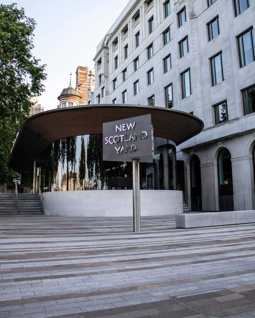 Professional institutional presence exemplifies importance of visible signage for establishing credibility and findability New Scotland Yard's prominent entrance with distinctive circular canopy and clear signage demonstrates how professional institutions establish visible presence and credibility.