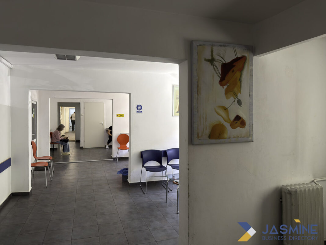 Modern institutional corridor exemplifies organized public service spaces central to government directories and civic navigation A clean institutional corridor with white walls and dark flooring features plastic chairs and abstract artwork, illustrating the organized spaces where government directories guide public access to services.