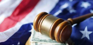 Why US law firms belong in a legal directory Wooden judicial gavel with gold band rests on dollar bills and American flag, representing the legal authority and financial aspects of law firm services.