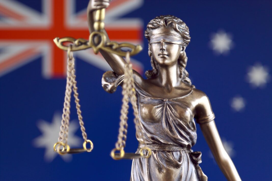Lady Justice statue symbolizing the Australian legal system and judicial authority for legal directory reference Bronze Lady Justice statue holding scales against Australian flag background, symbolizing the legal system and judicial authority referenced in legal directories.