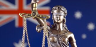 Top legal directories for australian lawyers in 2026 Bronze Lady Justice statue holding scales against Australian flag background, symbolizing the legal system and judicial authority referenced in legal directories.
