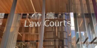 A guide to australian lawyer directory listings in 2026 Glass entrance of a Law Courts building with Australian coat of arms and white signage, illustrating the legal infrastructure accessed through Australian lawyer directory listings.