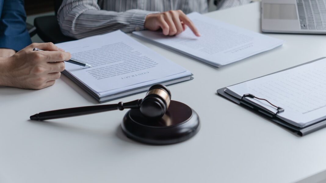 Legal consultation meeting illustrating professional solicitor services and client guidance A gavel rests on a conference table as two people review legal documents during a consultation, representing professional solicitor services and client guidance.