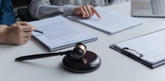 The best directories for UK solicitor practices A gavel rests on a conference table as two people review legal documents during a consultation, representing professional solicitor services and client guidance.