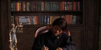 How Australian solicitors choose a legal directory Legal professional in judicial robes writing at desk with gavel and law books, representing the deliberative process solicitors use when choosing legal directories.
