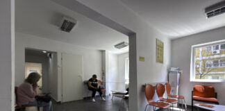 2026: Best physician directories serving UK Modern medical office waiting area with orange chairs and patients seated, representing the professional healthcare environments featured in physician directory listings.