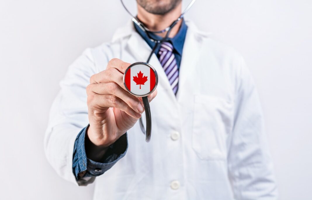 Canadian physician with maple leaf stethoscope representing nationwide physician directory services Medical professional in white lab coat extends stethoscope with Canadian flag on chest piece, symbolizing physician directory services across Canada.