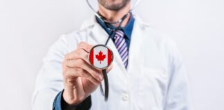 Medical professional in white lab coat extends stethoscope with Canadian flag on chest piece, symbolizing physician directory services across Canada.
