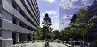 Modern office complex entrance with glass buildings and security barriers, representing professional business infrastructure for legal directory searches.
