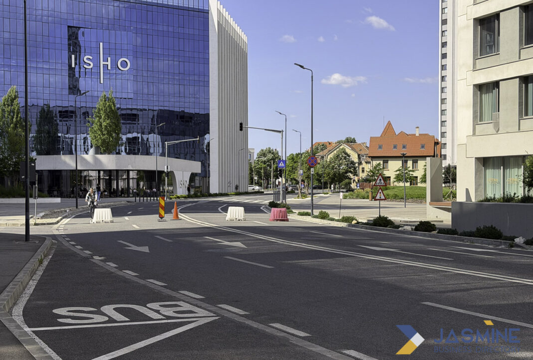 Commercial district architecture illustrating metropolitan legal infrastructure for law firm directory guidance Modern glass office building at an urban street intersection with traffic markings and traditional buildings, representing the professional commercial environment of metropolitan legal services.