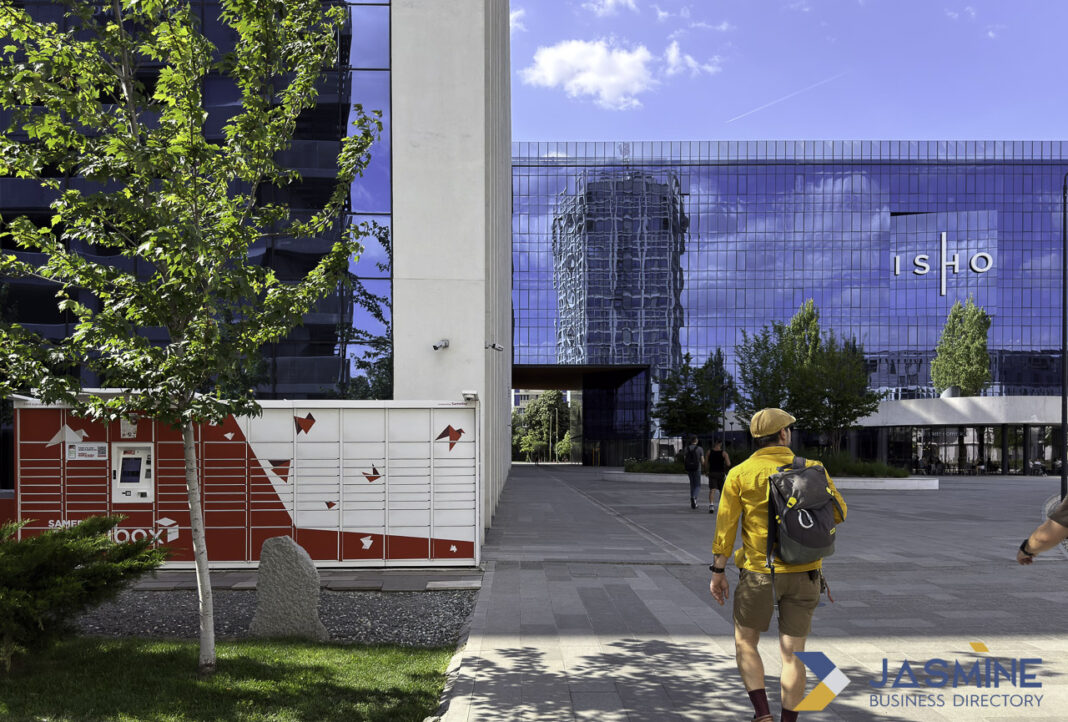 Modern business district infrastructure exemplifies organized connectivity in digital directory services Modern glass office buildings and parcel locker stations in an urban business plaza, illustrating the physical infrastructure supporting digital connectivity and business directory services.