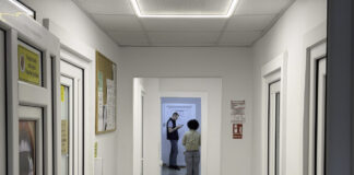 Minnesota law firm web directory listings explained Modern office corridor with white walls and multiple doorways showing two people in the background, representing the professional workspace infrastructure of law firms.