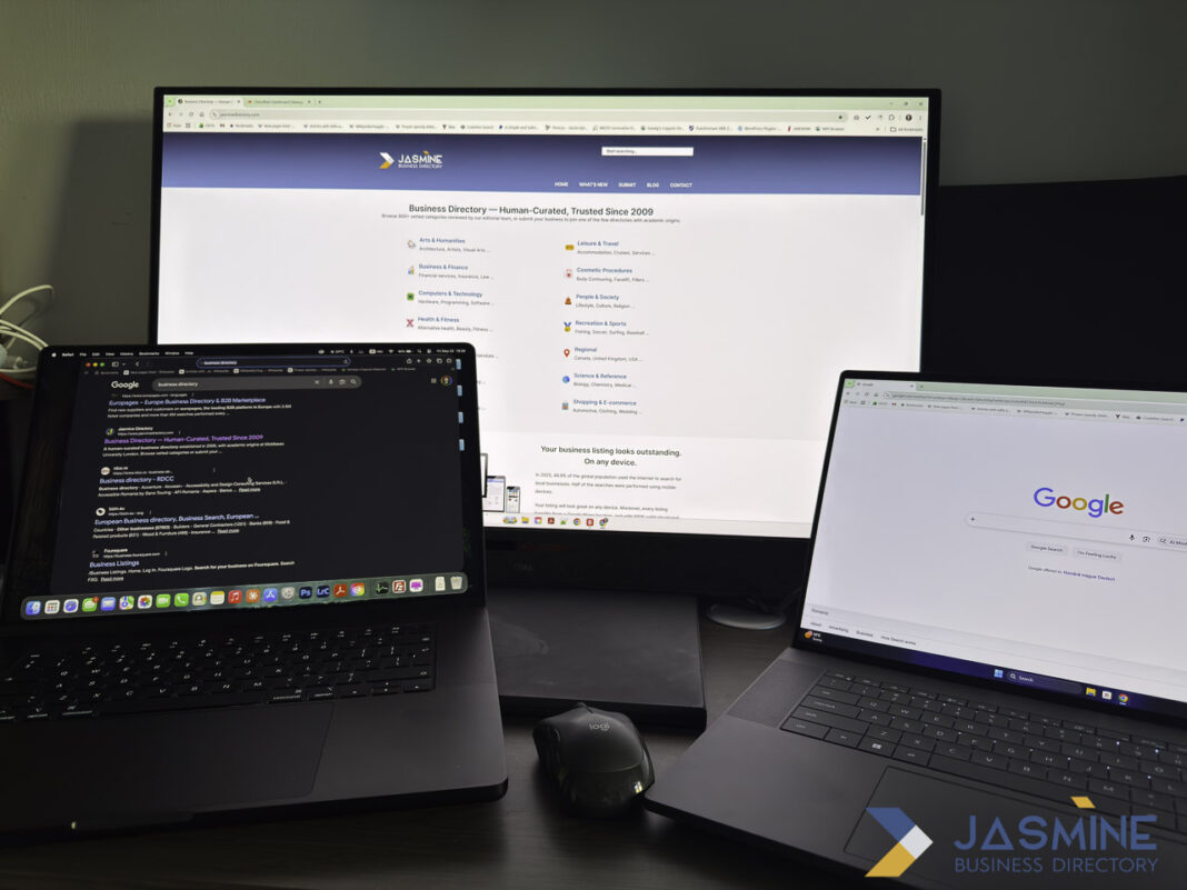 Multi-screen workstation setup for managing multiple business listings efficiently Three computer monitors and laptops displaying business directory websites on a professional desk setup, illustrating tools for managing multiple business listings.