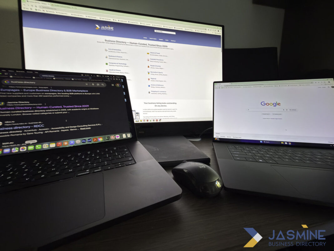 Multi-screen workstation setup demonstrates the digital environment for managing web directory submissions and online business listings Three-screen computer workstation with MacBook, external monitor displaying business directory website, and laptop showing Google homepage, illustrating the digital setup used for web directory submission work.