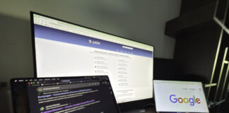 Three computer screens on a desk display various web pages including a business directory and search results, illustrating the digital tools used to optimize lawyer directory profiles.