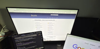 How to choose directories worth submitting to Three-screen workspace setup showing a monitor with business directory website, laptop with search results, and tablet with Google homepage, illustrating the directory evaluation process.