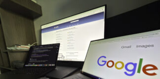 Three computer screens on a desk display different websites including a business directory and Google search, representing the digital research process attorneys use when selecting professional directories.