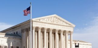How the Arizona law firm directory works in 2026 The neoclassical United States Supreme Court Building with prominent columns and American flag, representing the legal infrastructure that supports directories like Arizona's law firm resources.