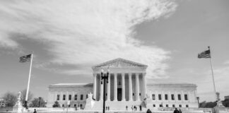 The USA law firm directory: a national 2026 guide Neoclassical Supreme Court building with Corinthian columns and American flags, representing the institutional legal framework supporting national law firm directories.