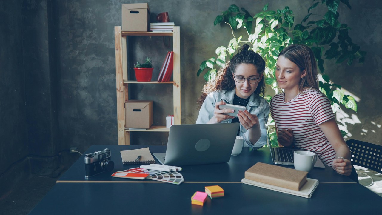 Office collaboration scene with two women