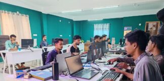 Directory listings for professional and creative services in 2026 Open-plan office with professionals working at computers and laptops at white workstations, representing the modern professional services landscape covered in business directory listings.