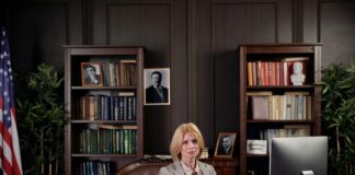 How to list your practice in a California based law firm directory? Professional woman working at an executive desk in a traditional wood-paneled office, illustrating the credible professional environment featured in California law firm directories.