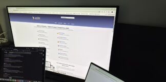 Two laptop computers display different business directory websites on their screens, illustrating the need to maintain consistent business information across multiple online platforms.