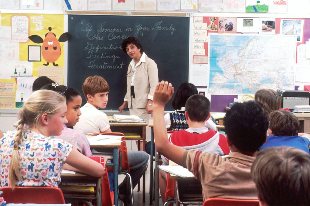classroom-teacher-blackboard-students-raising-hand