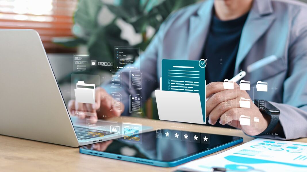 Professional workspace with organized digital interface elements illustrating clean website design principles Person working at laptop with overlaid digital interface graphics including folders and security elements, representing organized website design and streamlined user experience.