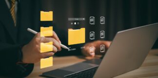 Person working on laptop with digital folder and document icons overlaid, representing automated directory management and data organization systems for business workflows.