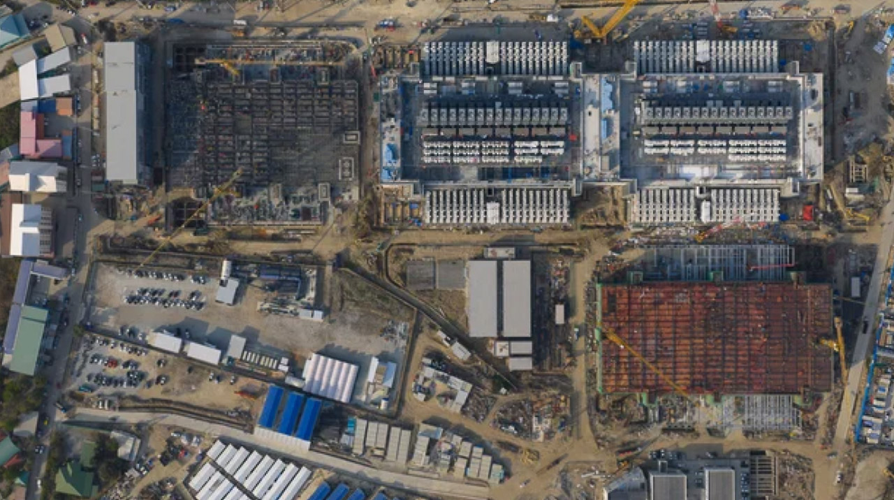 Aerial view of an industrial construction site with warehouses, crane, and organized building materials, symbolizing systematic foundation building and structured planning approach.